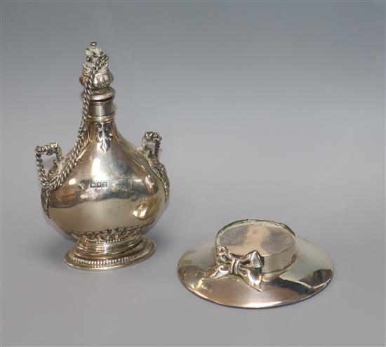 A George V silver scent flask, Goldsmiths & Silversmiths Co Ltd, London, 1917 and an Edwardian silver hat shaped photograph frame.